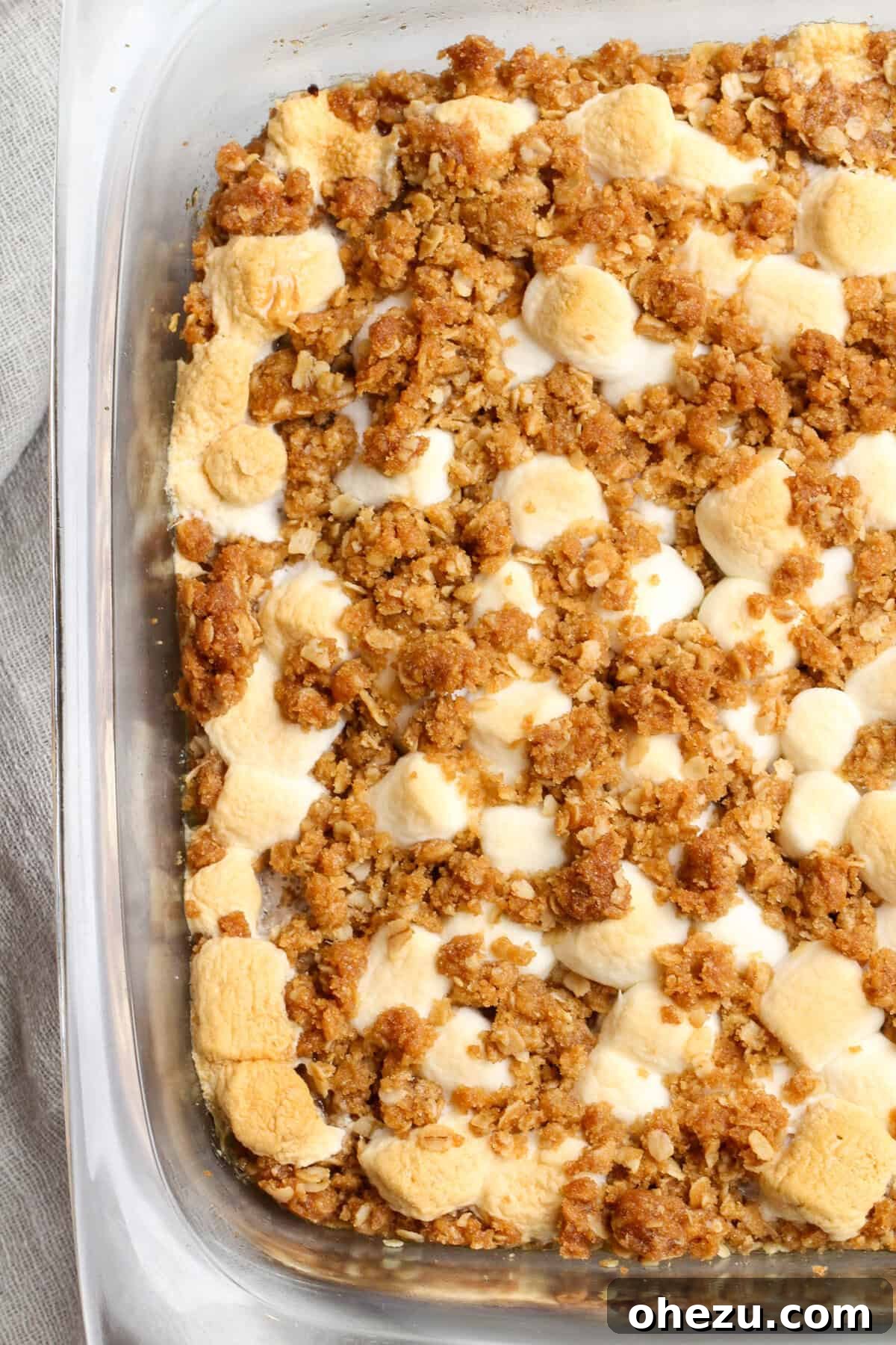Ingredients for Southern Sweet Potato Casserole laid out, including sweet potatoes, butter, spices, and marshmallows.