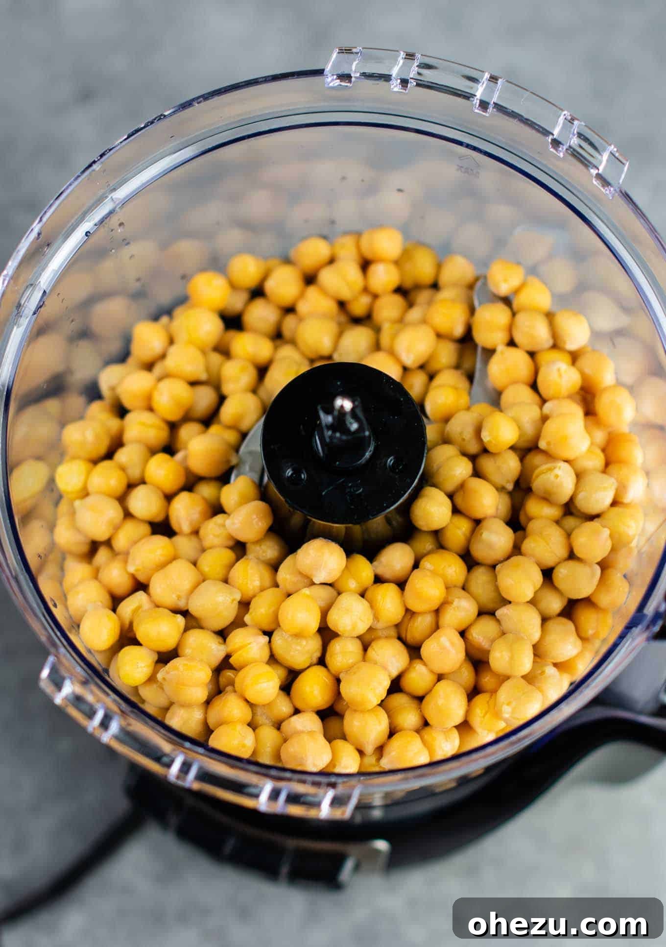 Golden Chickpea Bites 4 Drained and rinsed chickpeas being added to a food processor, the initial step in preparing meatless chicken nuggets.