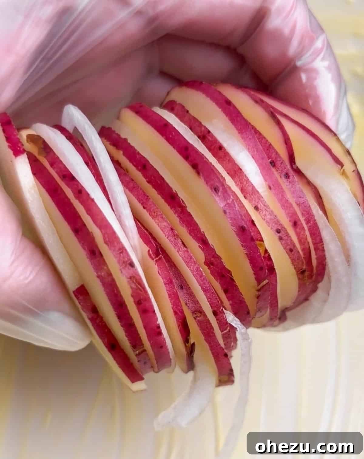 Layering potatoes and onions in a baking dish for Au Gratin