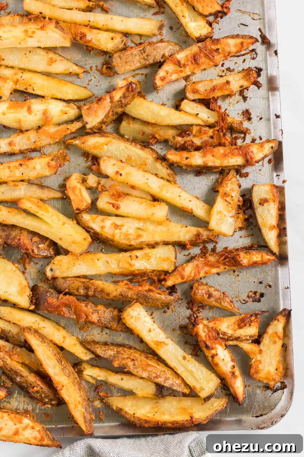 More perfectly baked potato wedges on a baking sheet, showcasing their beautiful golden color.