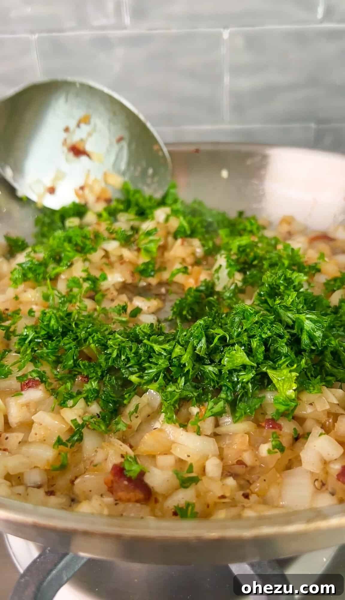 Onions, garlic, and parsley sautéing in a skillet