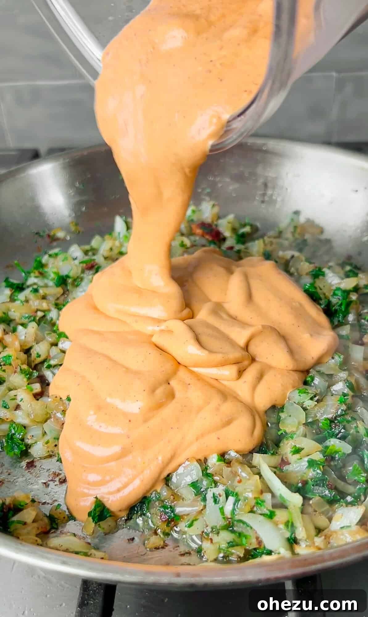 Chipotle Bacon Alfredo pasta being tossed in a skillet
