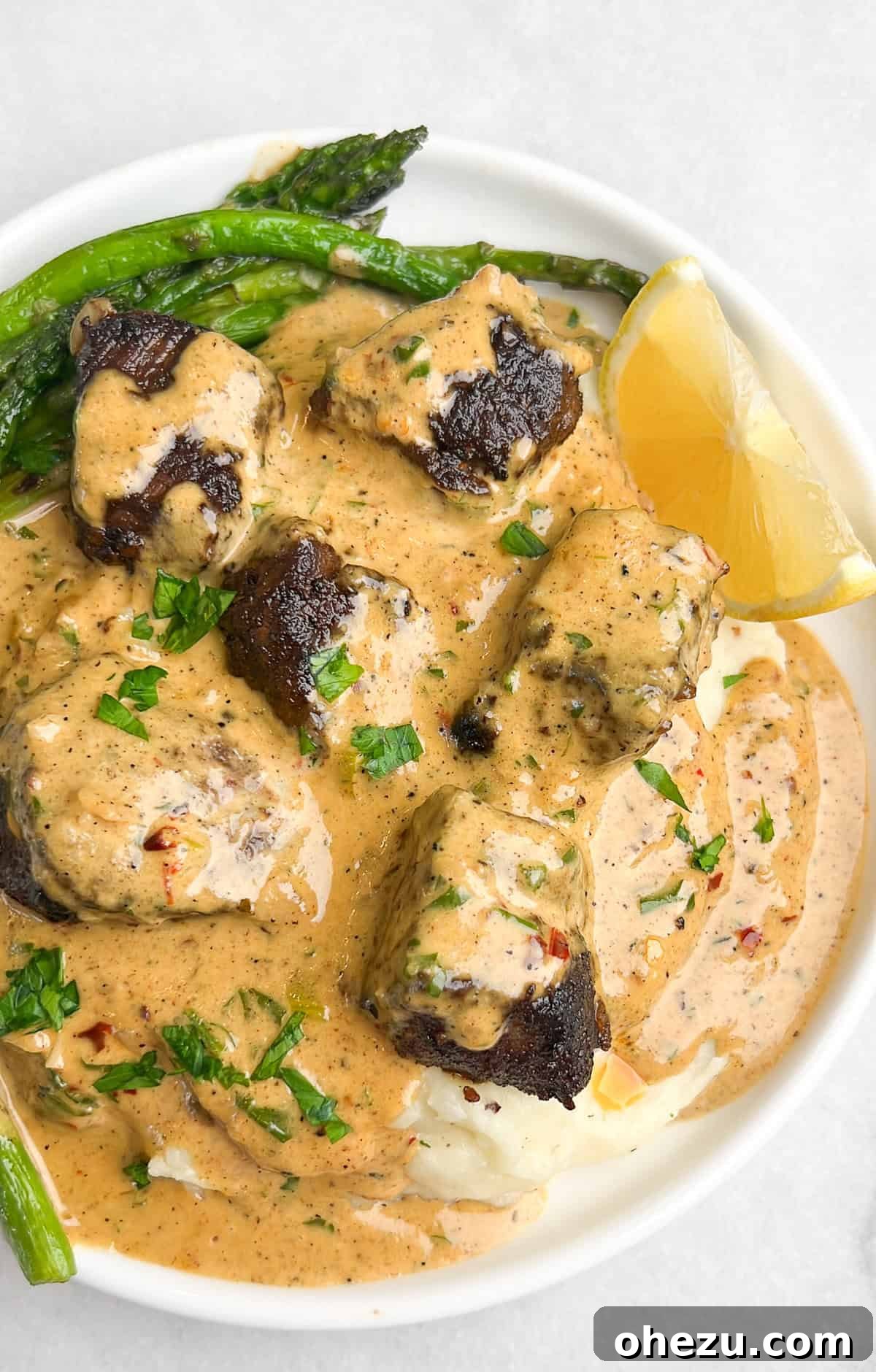 Garlic Butter Steak Bites with Parmesan Cream Sauce served over mashed potatoes