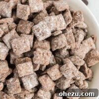 Bowl of vegan muddy buddies, coated in powdered sugar.