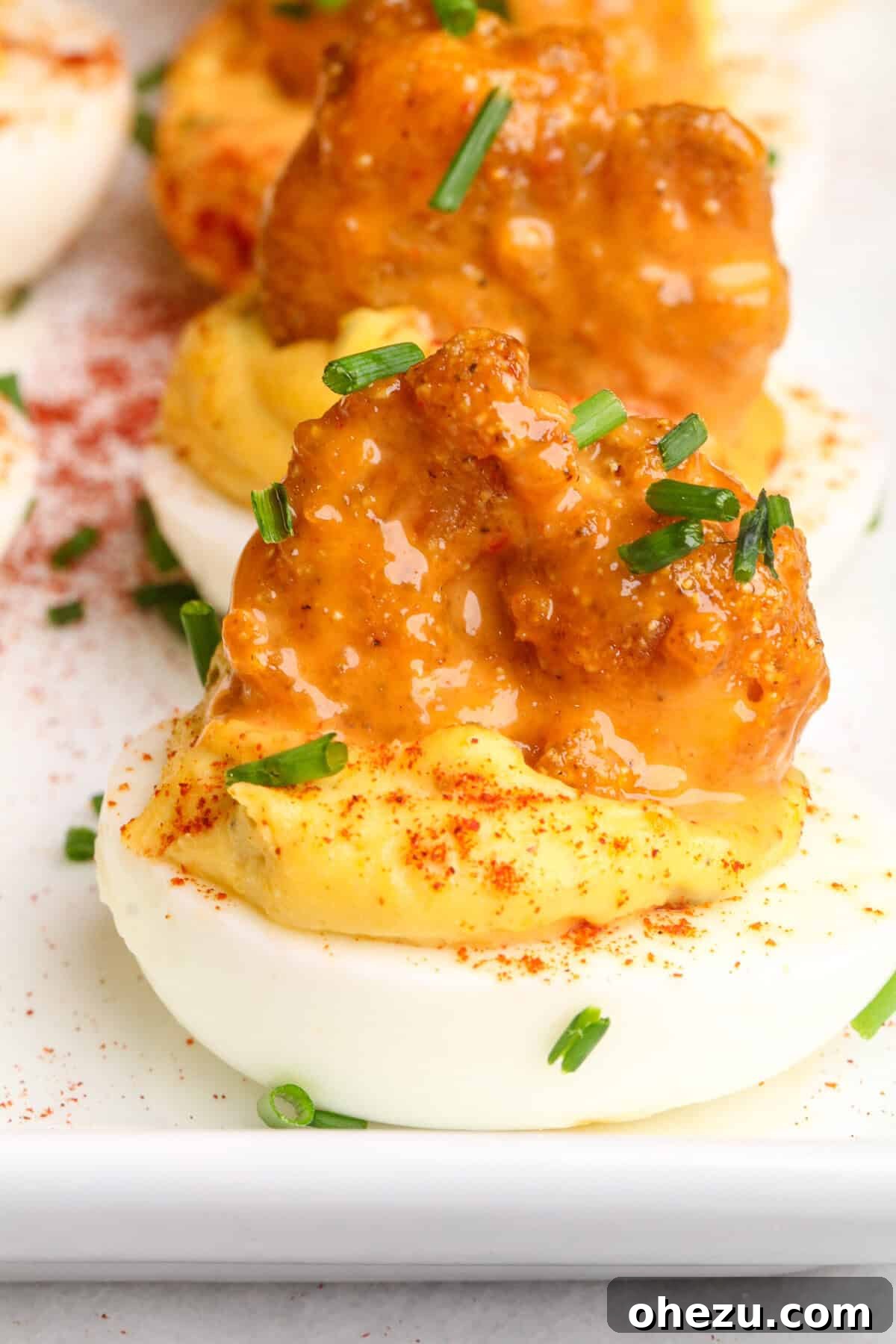 Dynamite Cajun Shrimp Deviled Eggs 5 Completed Firecracker Shrimp Deviled Eggs artfully arranged on a serving platter, garnished with fresh chives