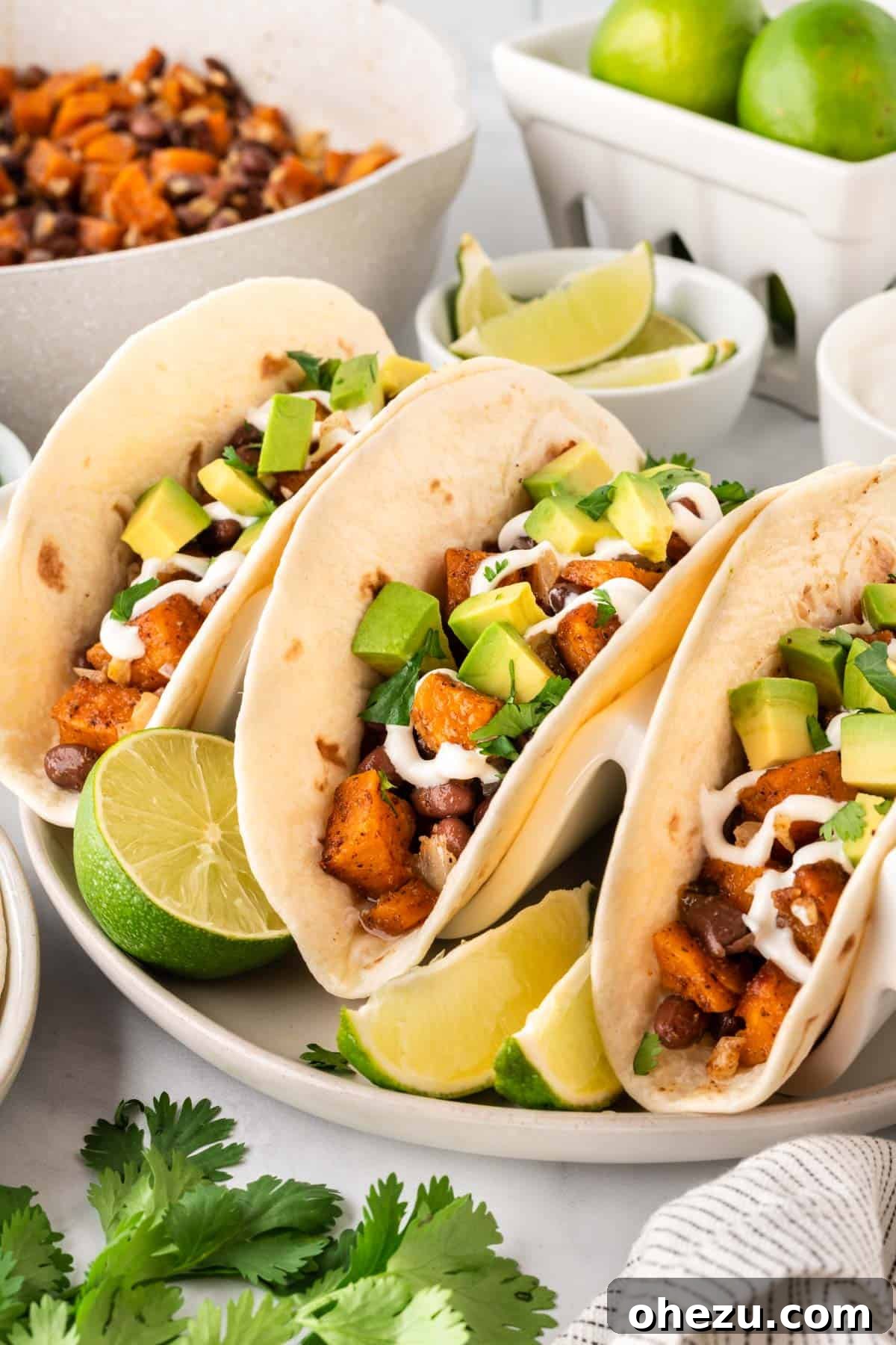Delicious sweet potato tacos topped with creamy sour cream and fresh diced avocado