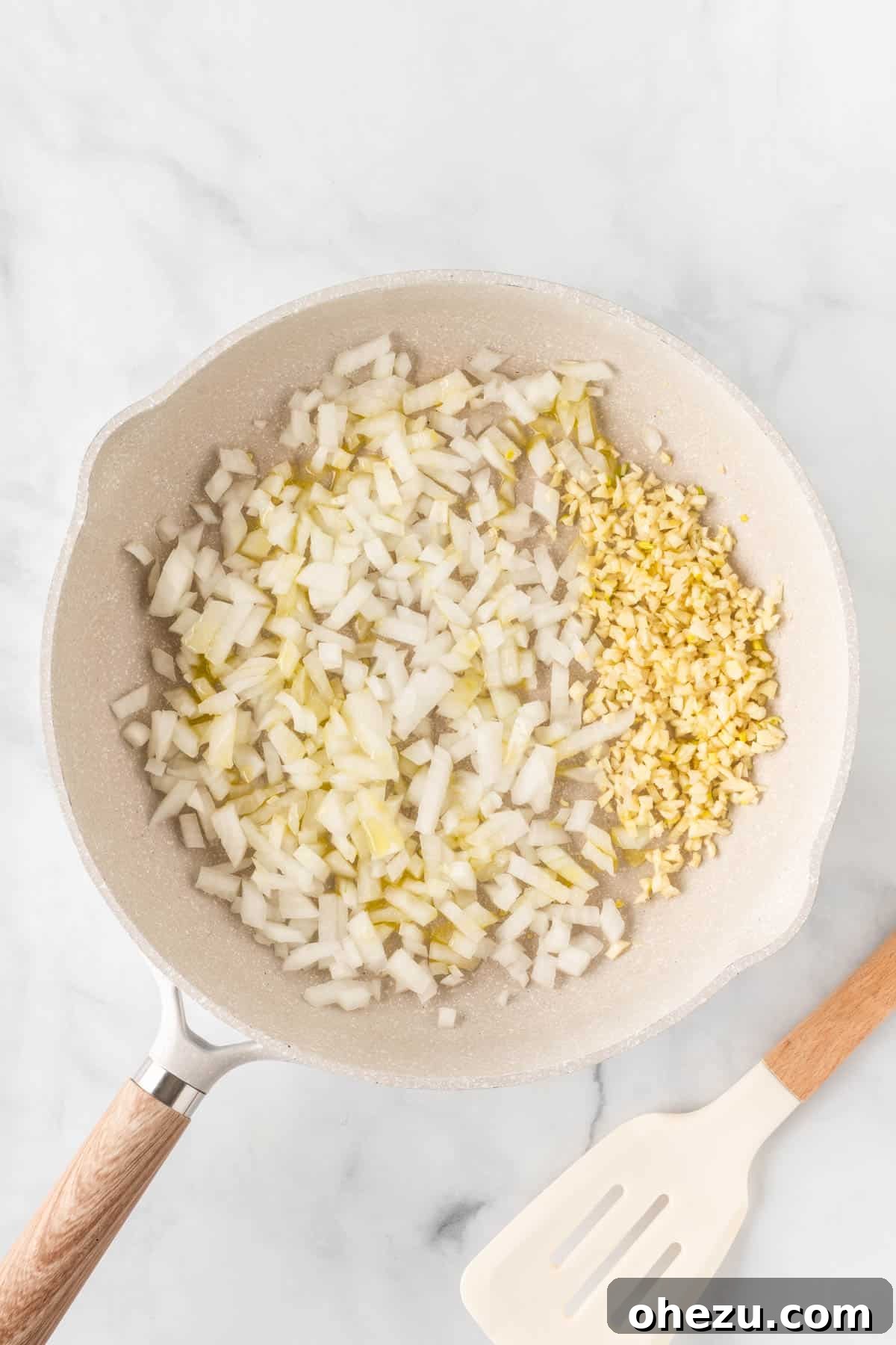 Fragrant garlic and diced onion sautéing in olive oil in a hot skillet