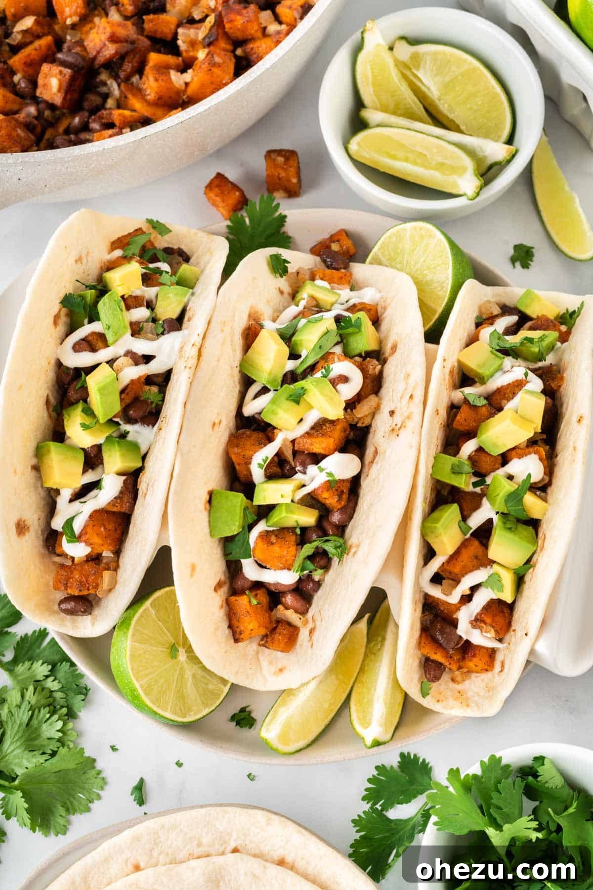 A trio of sweet potato tacos, freshly prepared and beautifully garnished
