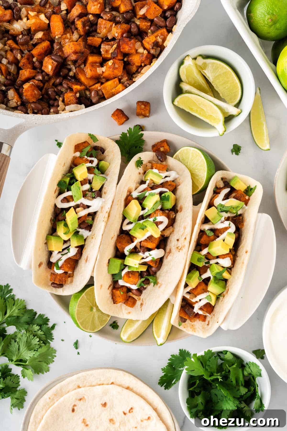 Close-up of sweet potato tacos garnished with sour cream and avocado