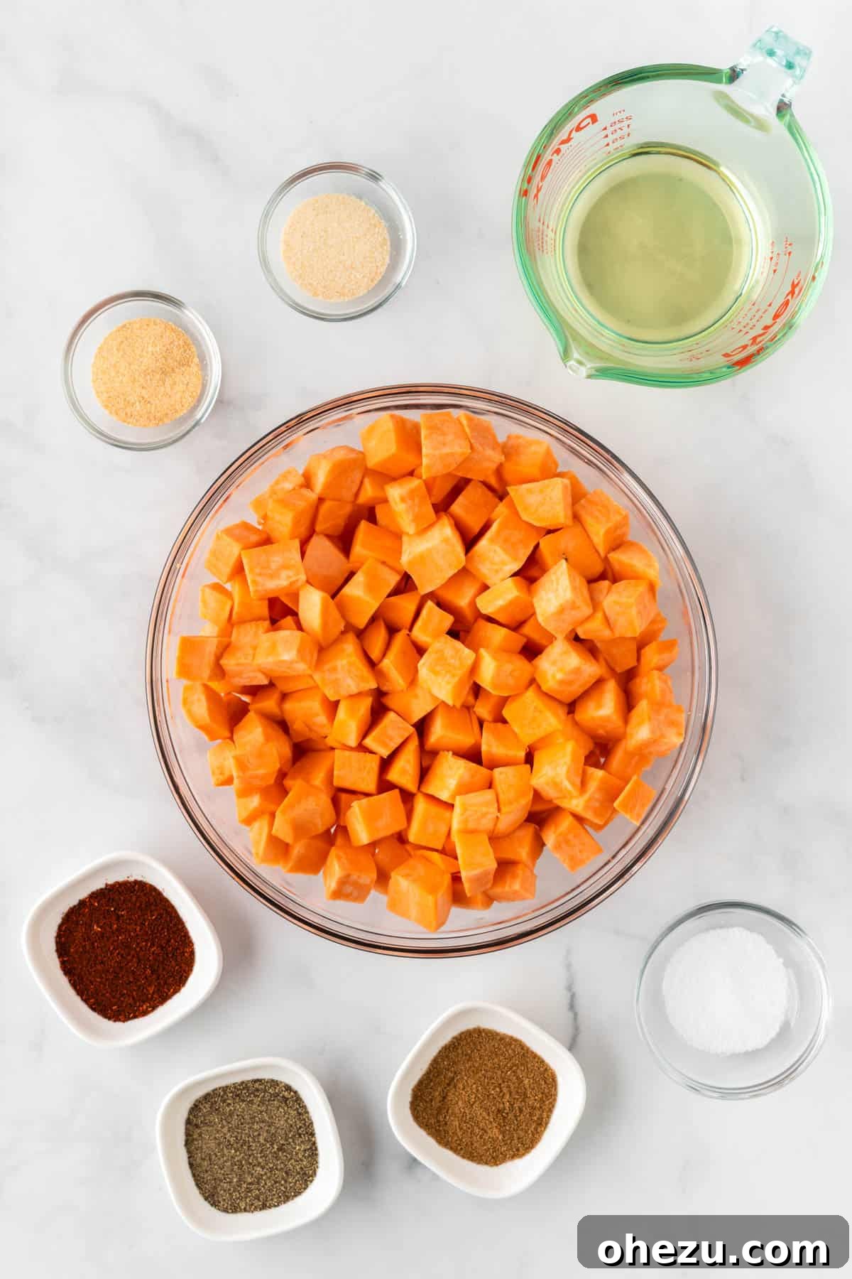 Diced sweet potatoes in a bowl, ready to be seasoned with olive oil and spices