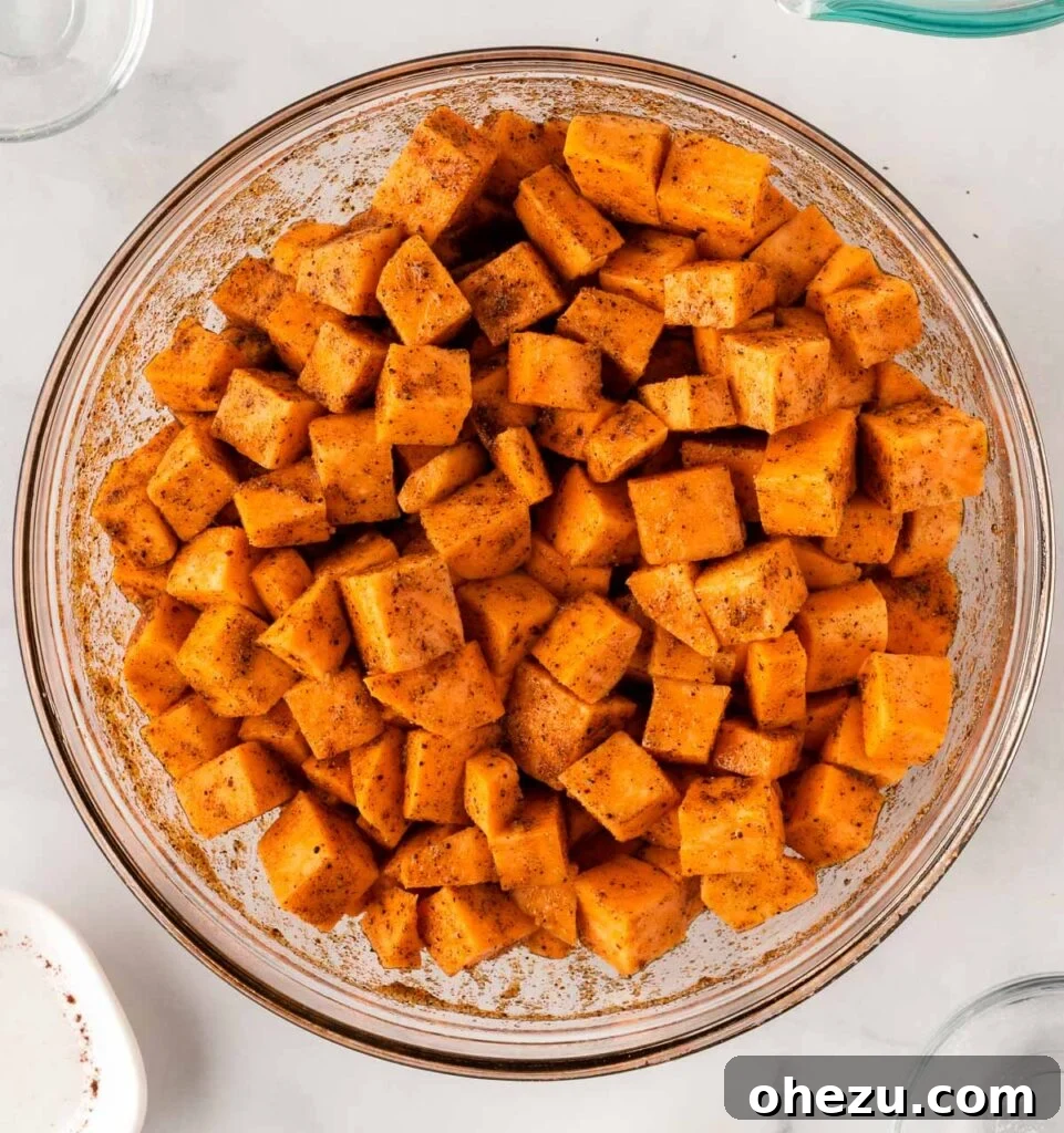 Spiced sweet potato cubes expertly mixed and coated for roasting