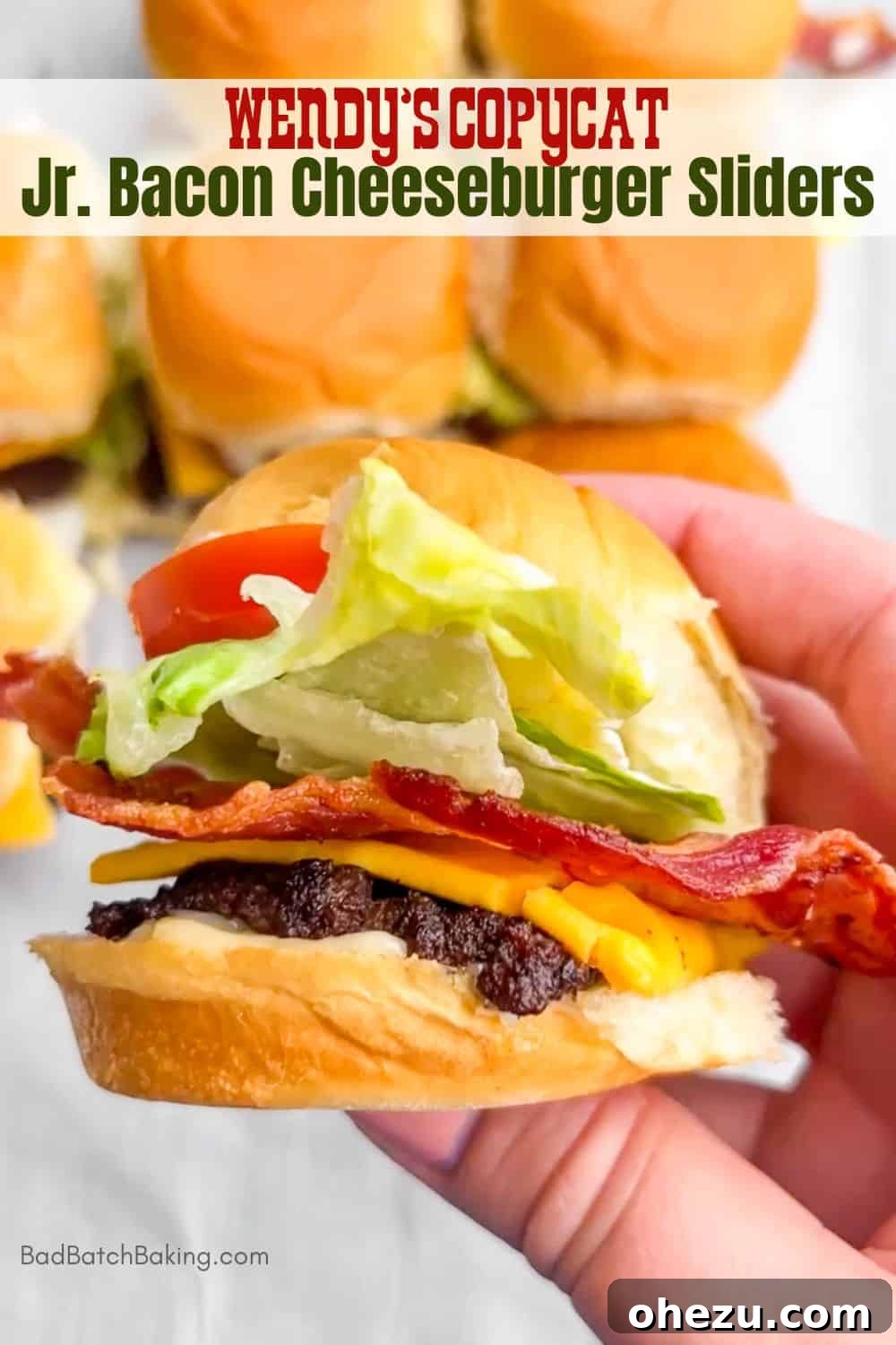 Four Jr. Bacon Cheeseburger Sliders stacked on a serving board, garnished with fresh lettuce and tomato.