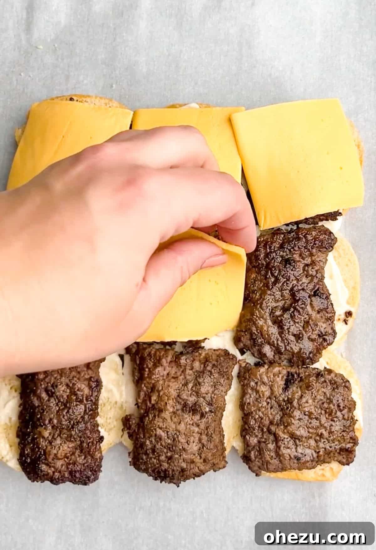 Process shot: Flipping burger patties in the skillet to cook the other side.