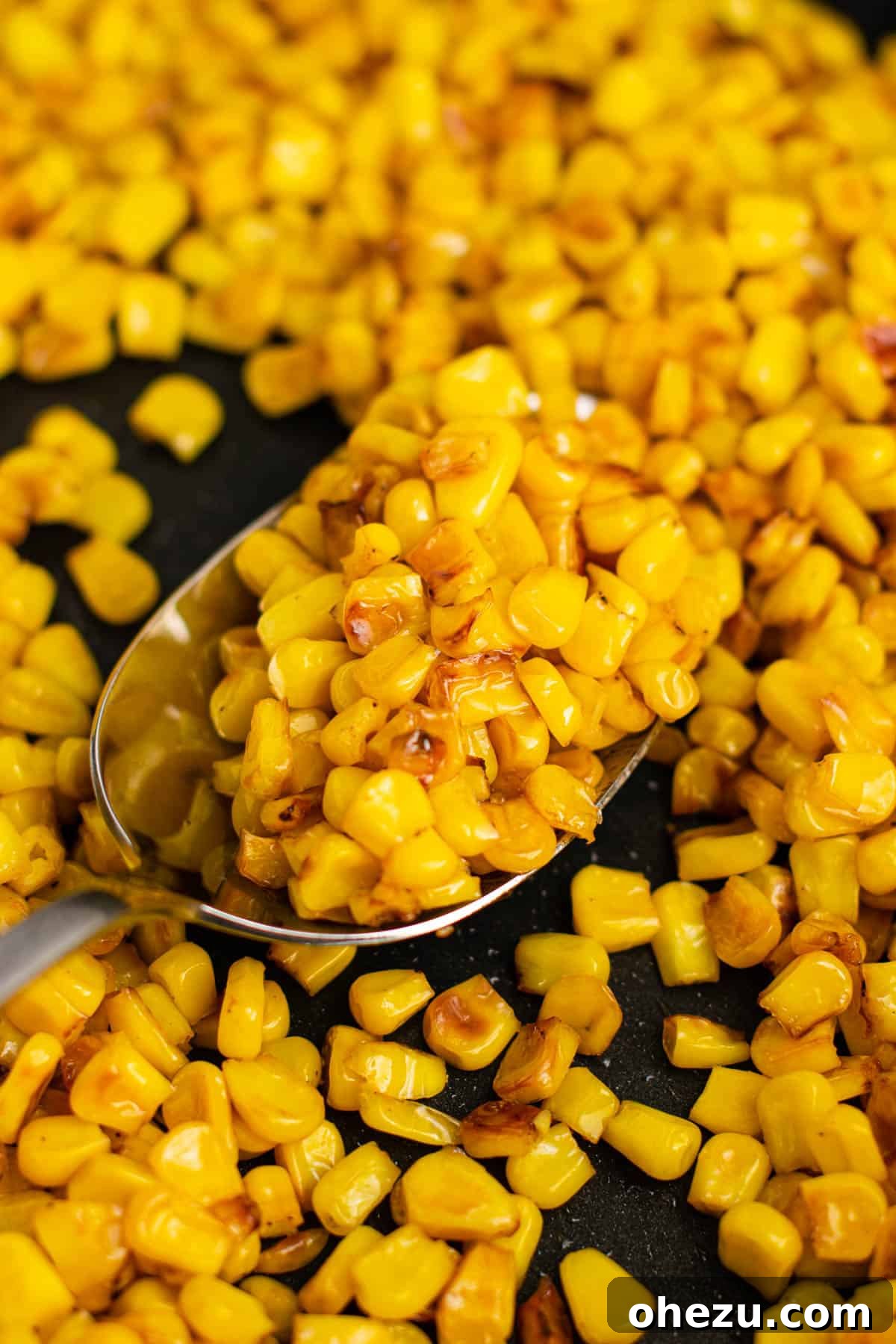 Sizzling Skillet Corn 3 taking a spoonful of golden caramelized corn from the skillet
