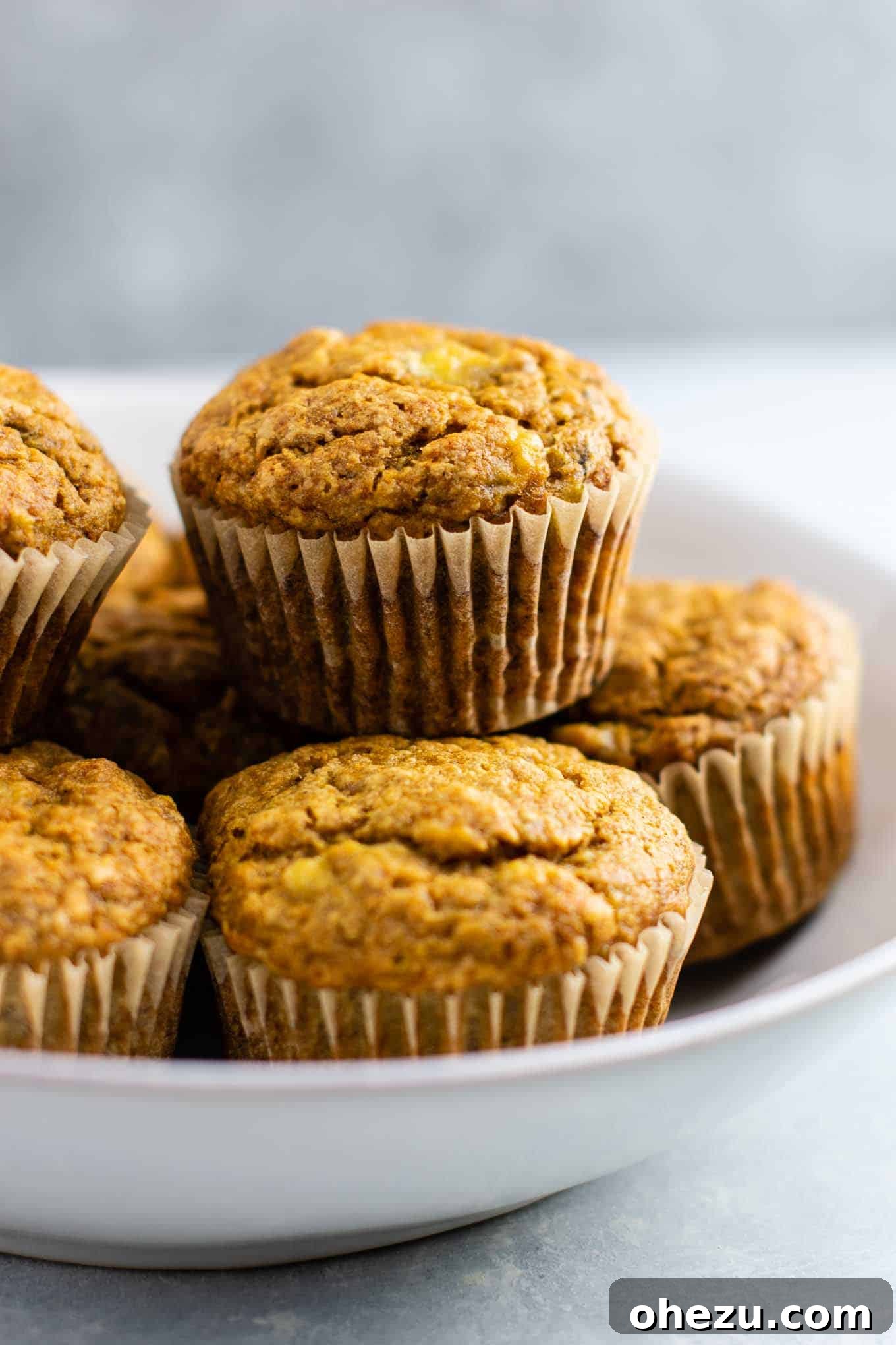 A single perfectly baked vegan banana muffin, showcasing its golden-brown top and soft texture, ready to be enjoyed.