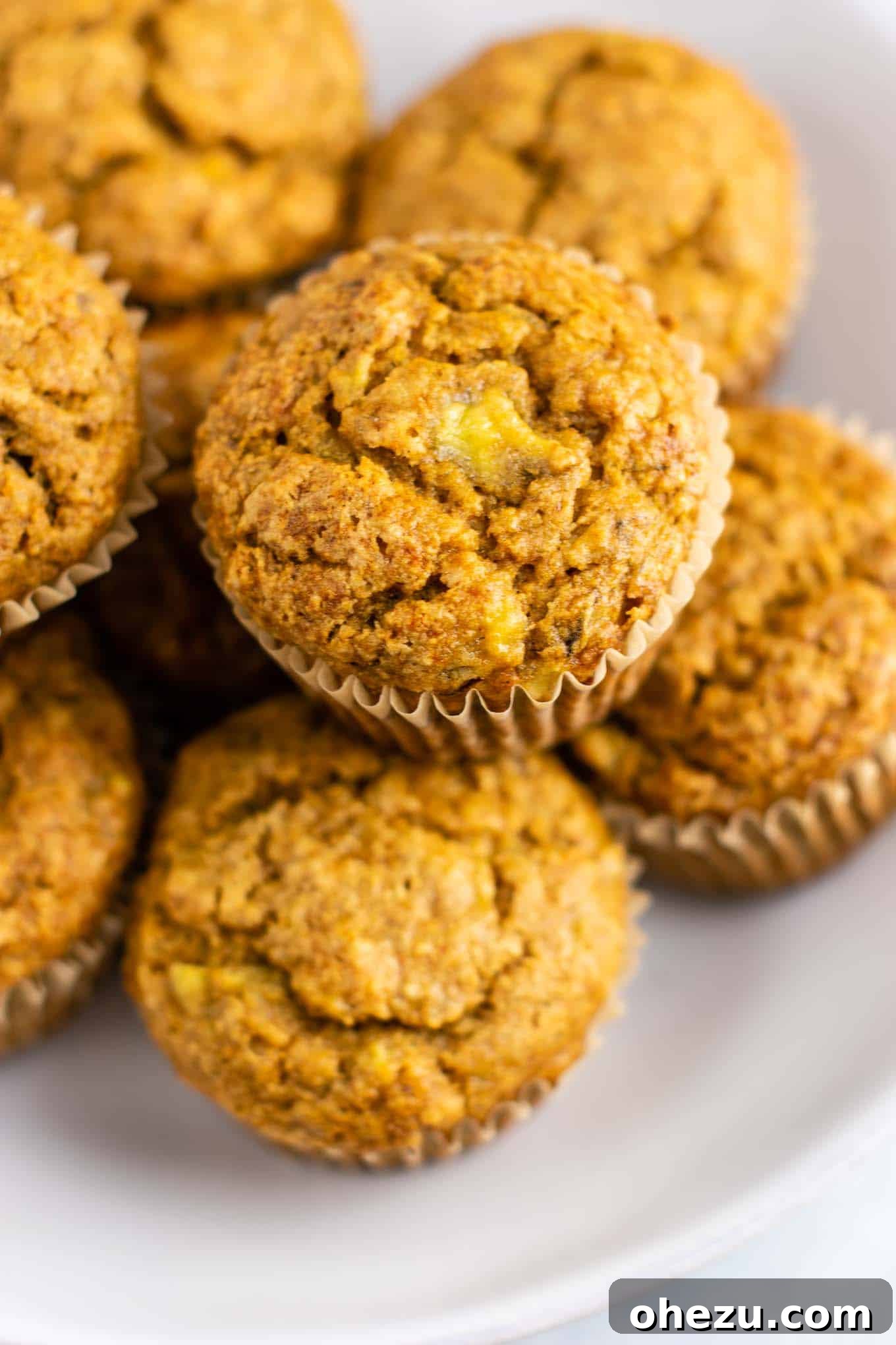 Three freshly baked easy vegan muffins cooling on a wire rack, highlighting their beautiful cracked tops.