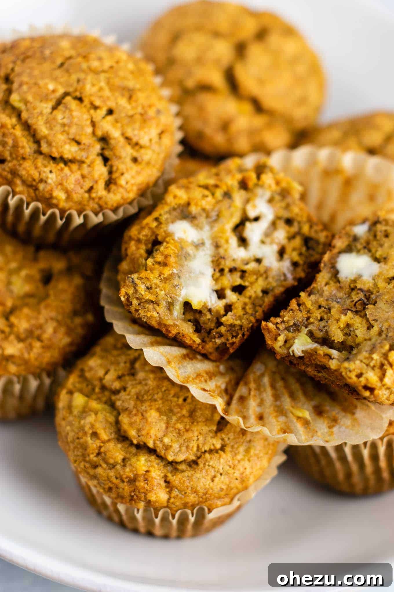 Warm vegan banana muffin topped with melted vegan butter, showcasing a rich and inviting texture.