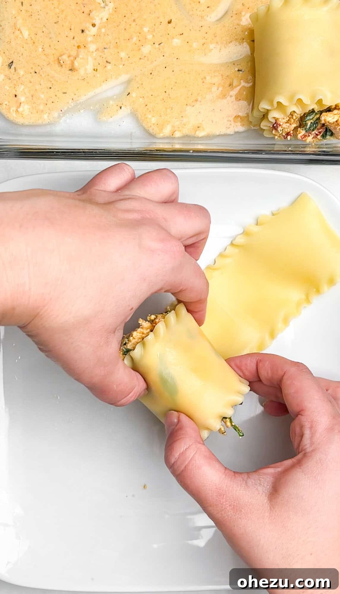 First few Cajun Chicken Lasagna Roll-ups placed in a baking dish