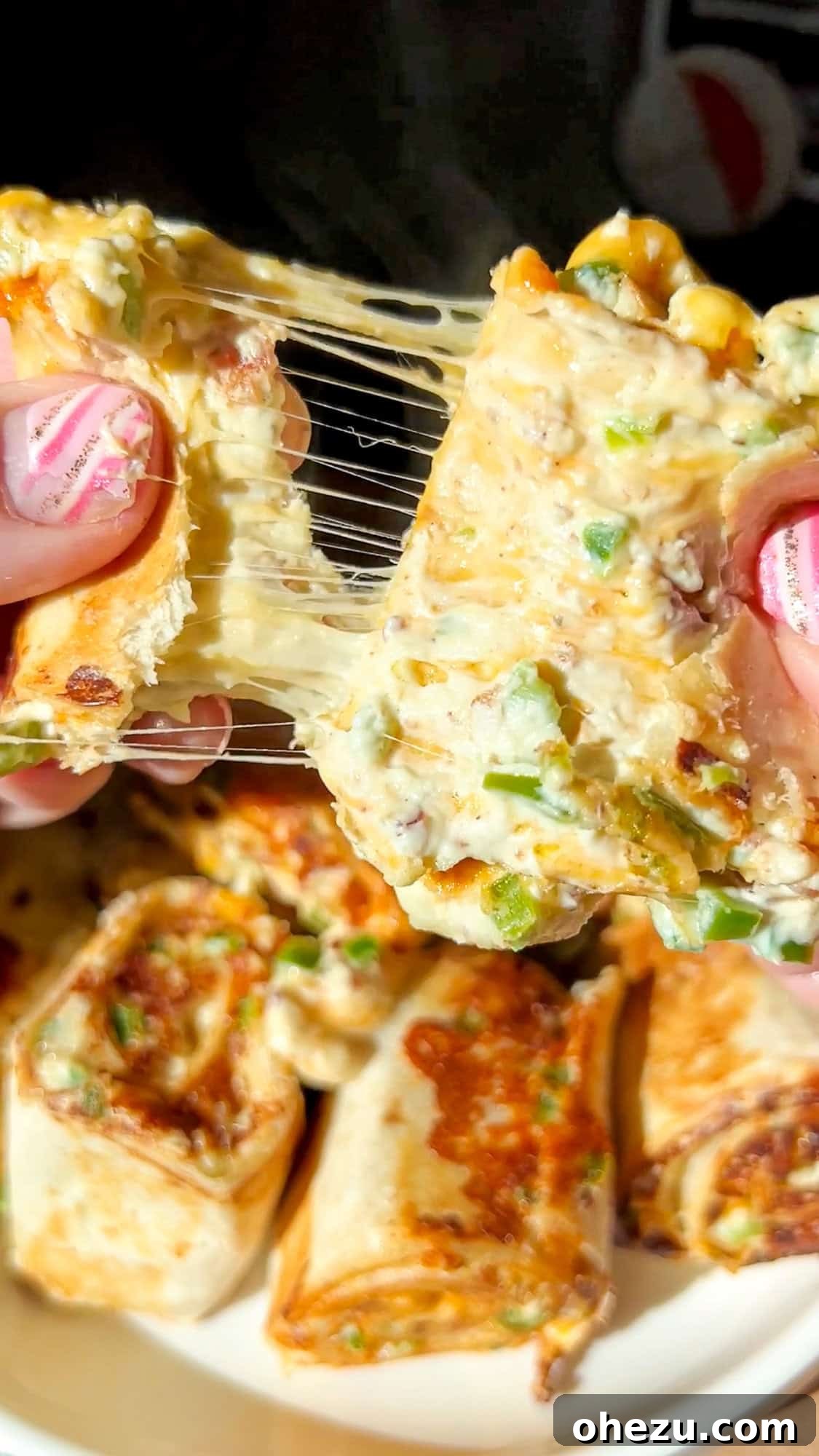A close-up of a stack of toasted pinwheel sandwiches with melted cheese and crispy edges