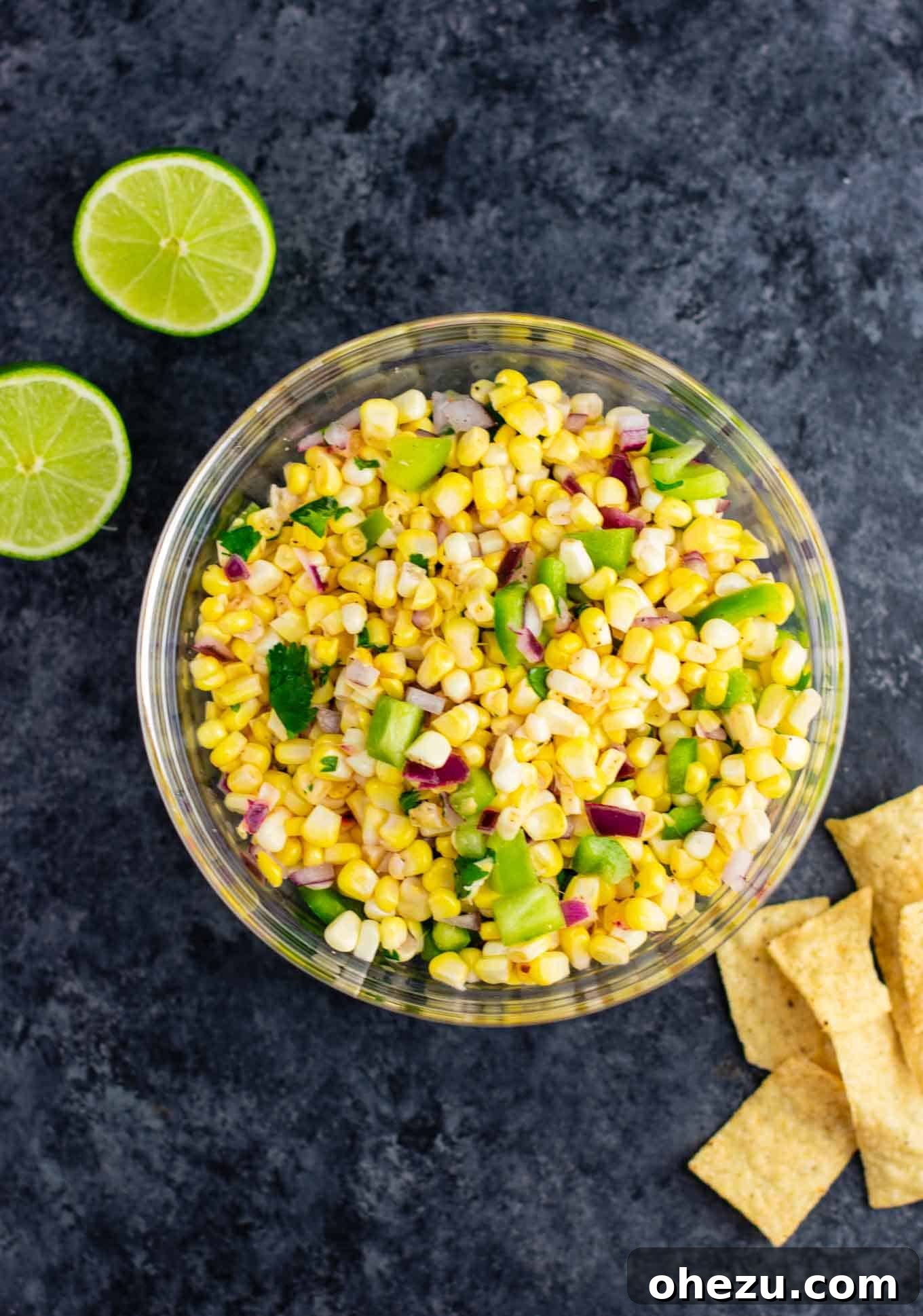 A vibrant bowl of fresh corn salsa with crisp corn kernels, red onion, green bell pepper, and cilantro, ready to be enjoyed.
