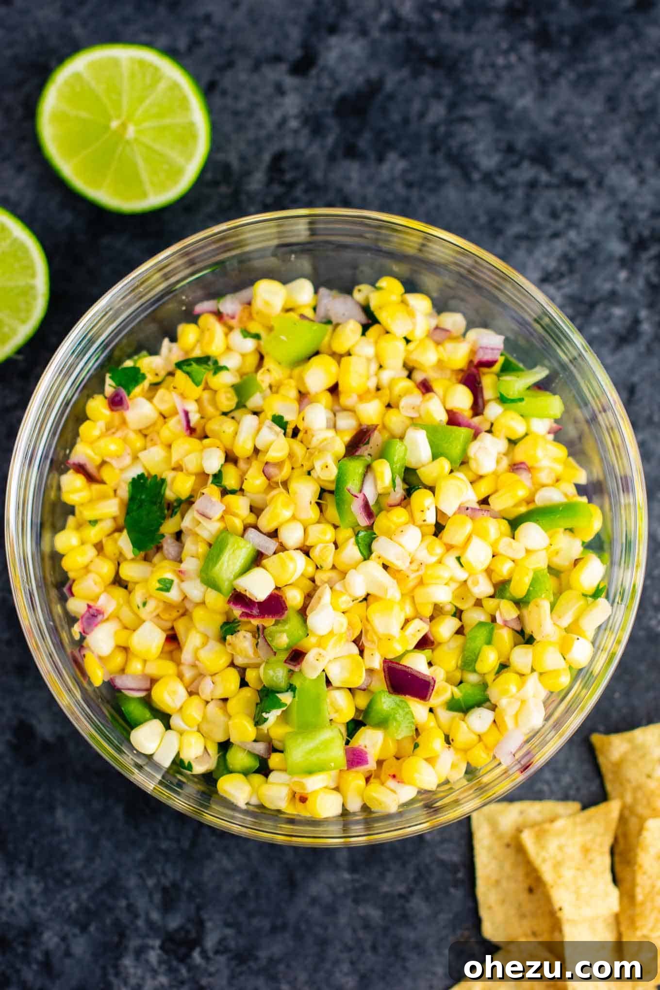 Close-up of fresh corn salsa, showcasing the vibrant colors and textures of corn, diced red onion, and green bell pepper.