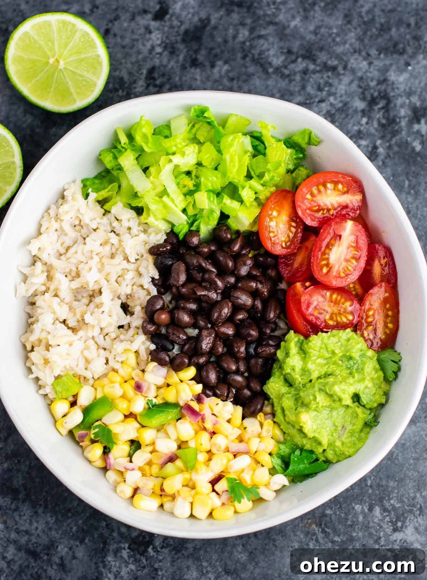 Overhead shot of a delicious vegan burrito bowl with fresh corn salsa, guacamole, and black beans. A healthy and satisfying plant-based meal prep idea. #veganburritobowl #healthymeals #plantbaseddinner #freshrecipes #homemadechipotle
