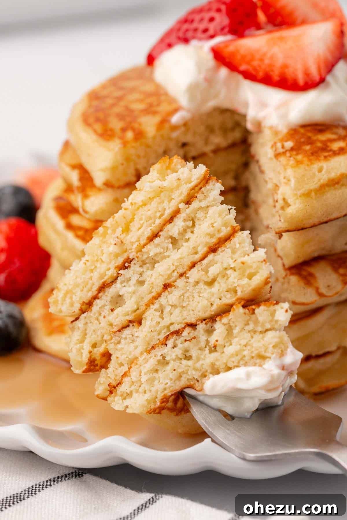 A single fluffy Greek yogurt pancake with a small bite taken out, showing its tender interior.