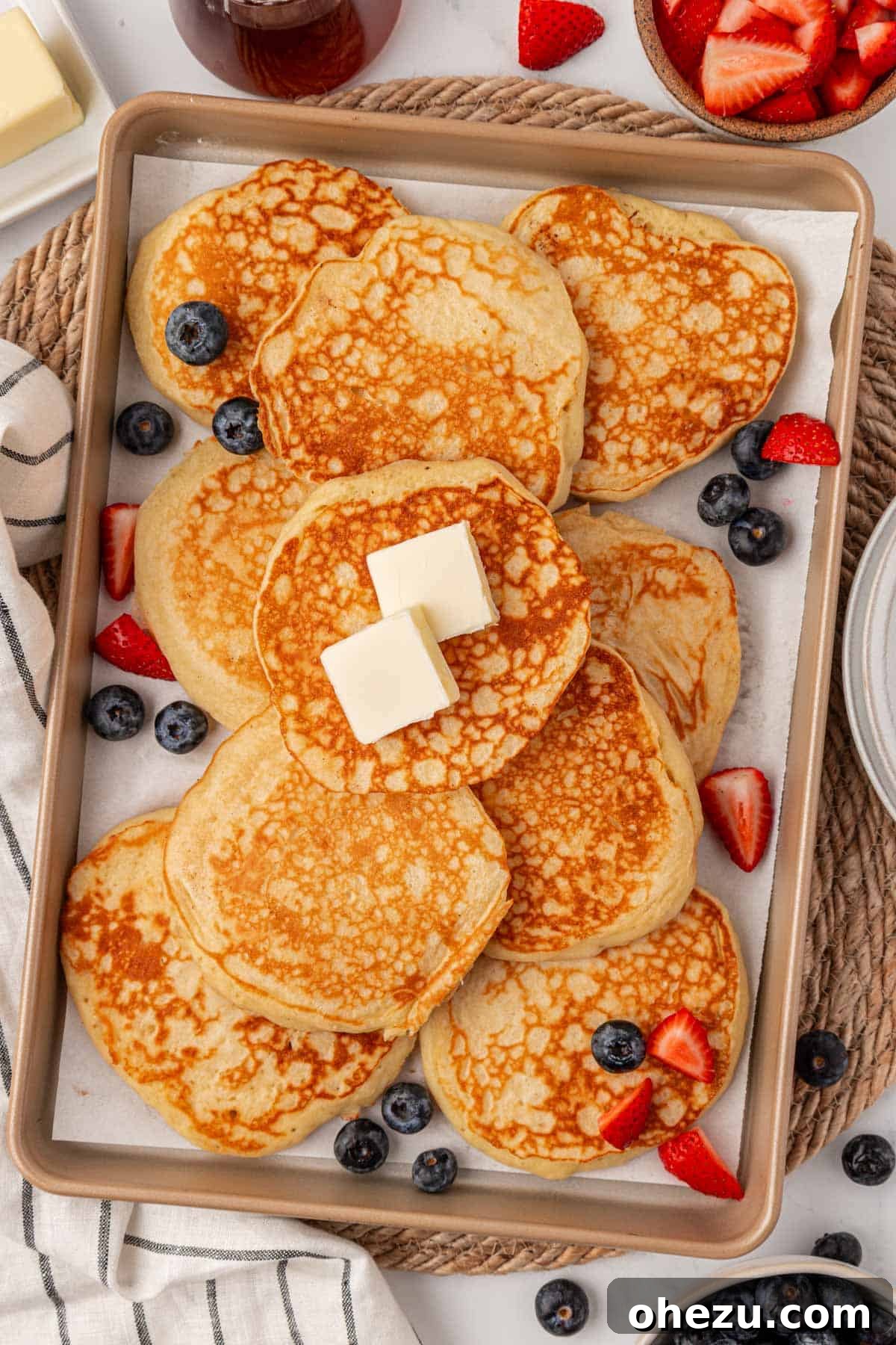 Close-up of a stack of Greek yogurt pancakes with a fork taking a bite, showing the fluffy interior.