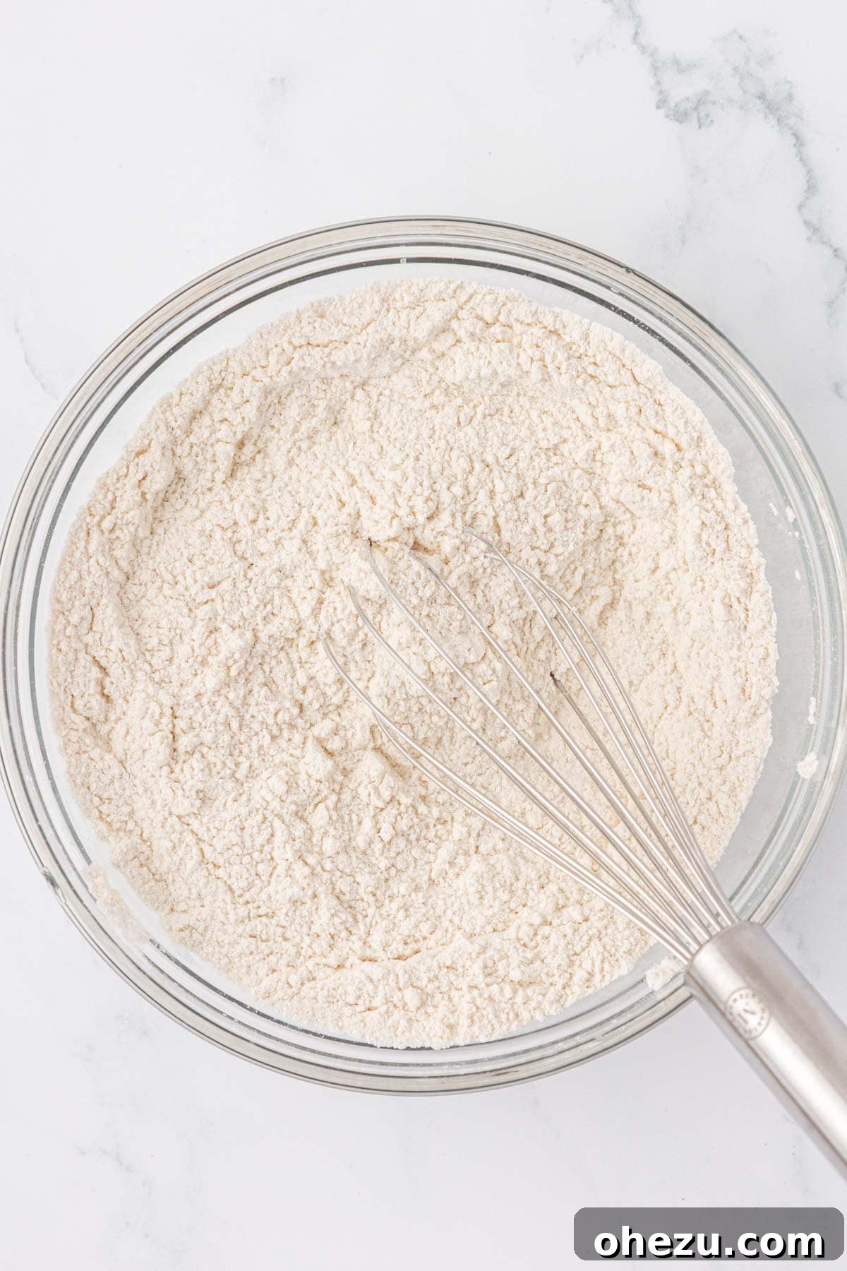 Whisked dry ingredients in a mixing bowl, ready for wet ingredients.