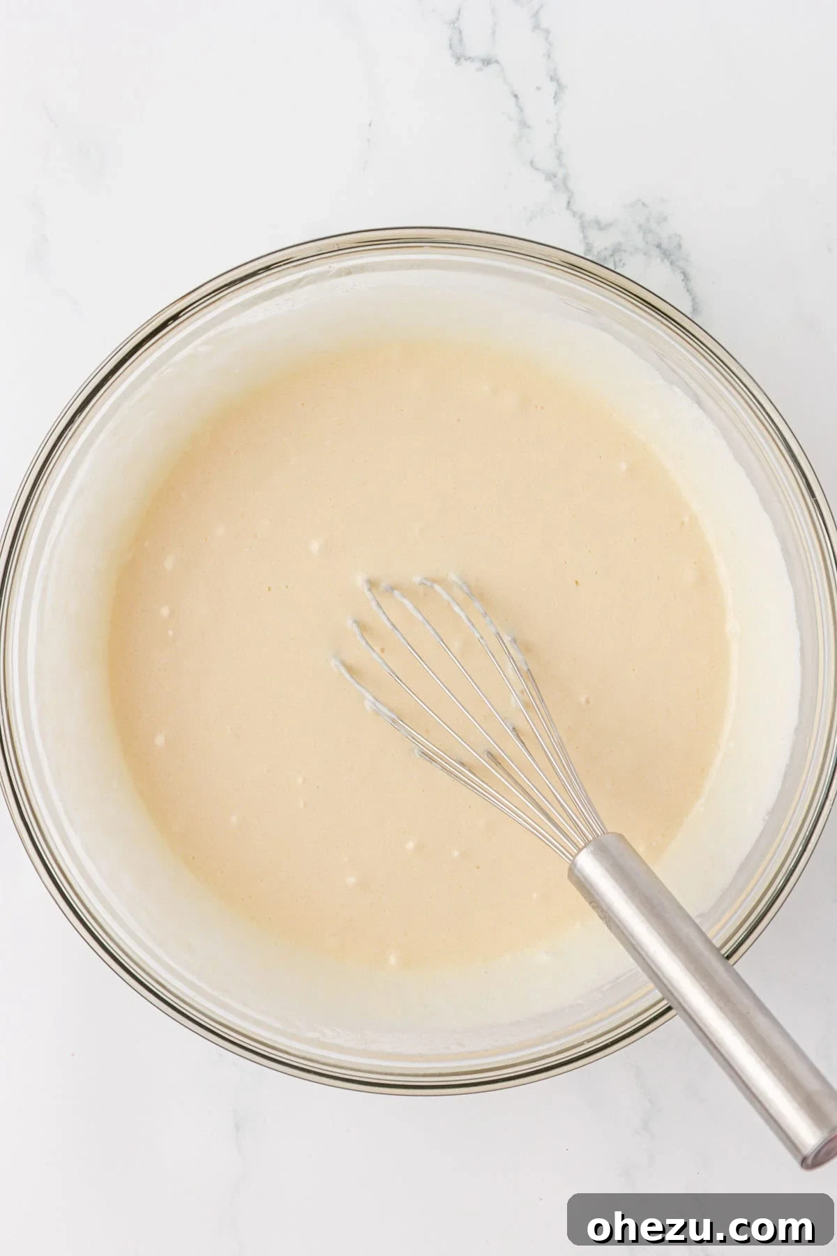 Whisked wet ingredients forming a smooth, uniform mixture.