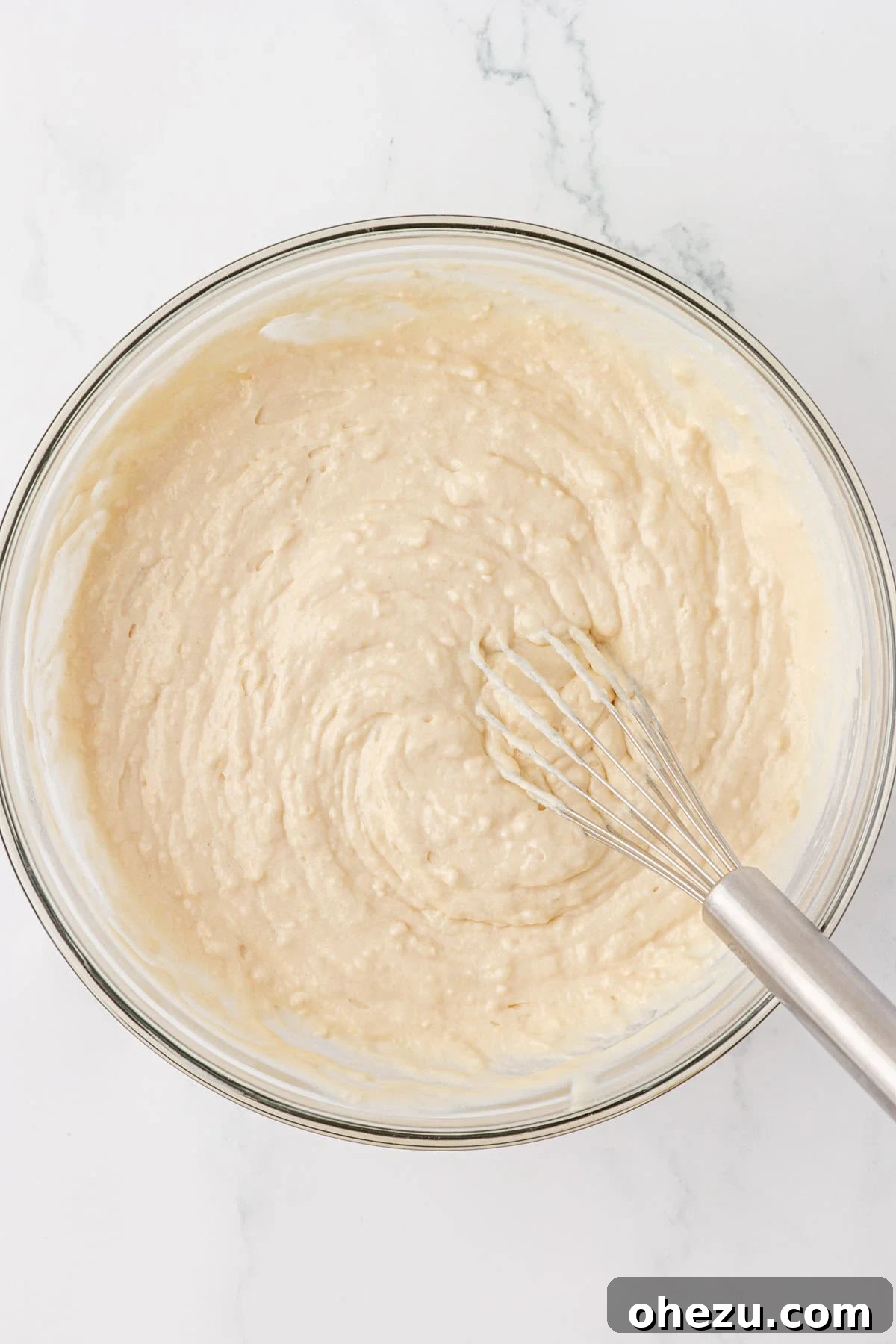 Pancake batter with a few small lumps, indicating it's perfectly mixed.
