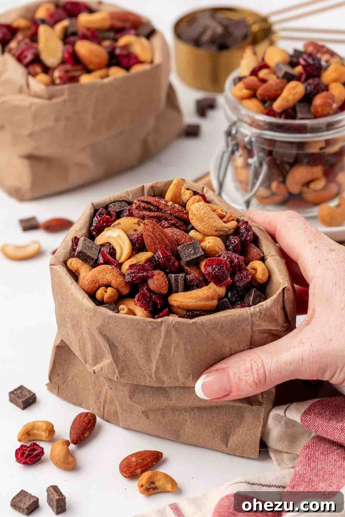 A small paper bag filled with homemade trail mix, carefully folded and ready for a convenient, on-the-go snack, highlighting its portability.