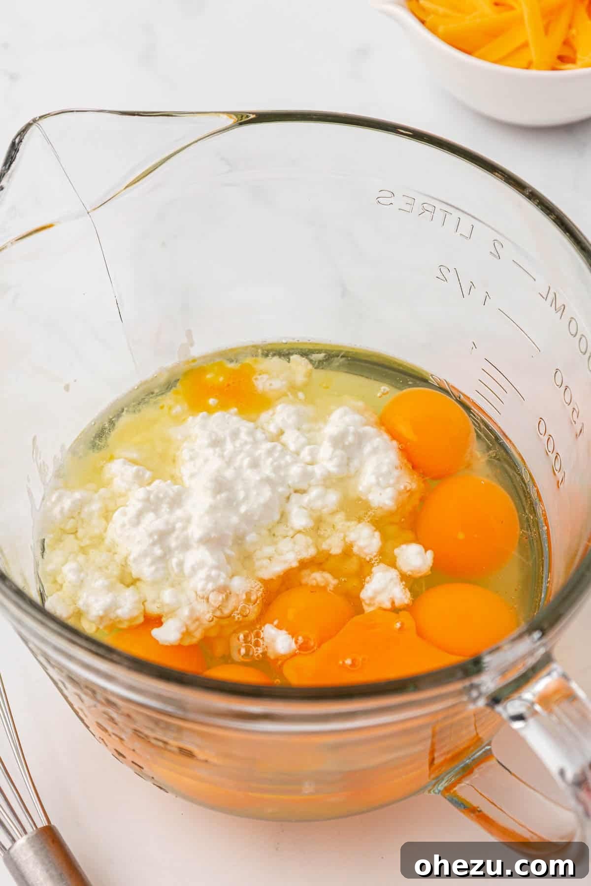 eggs and cottage cheese ready for whisking in a measuring cup