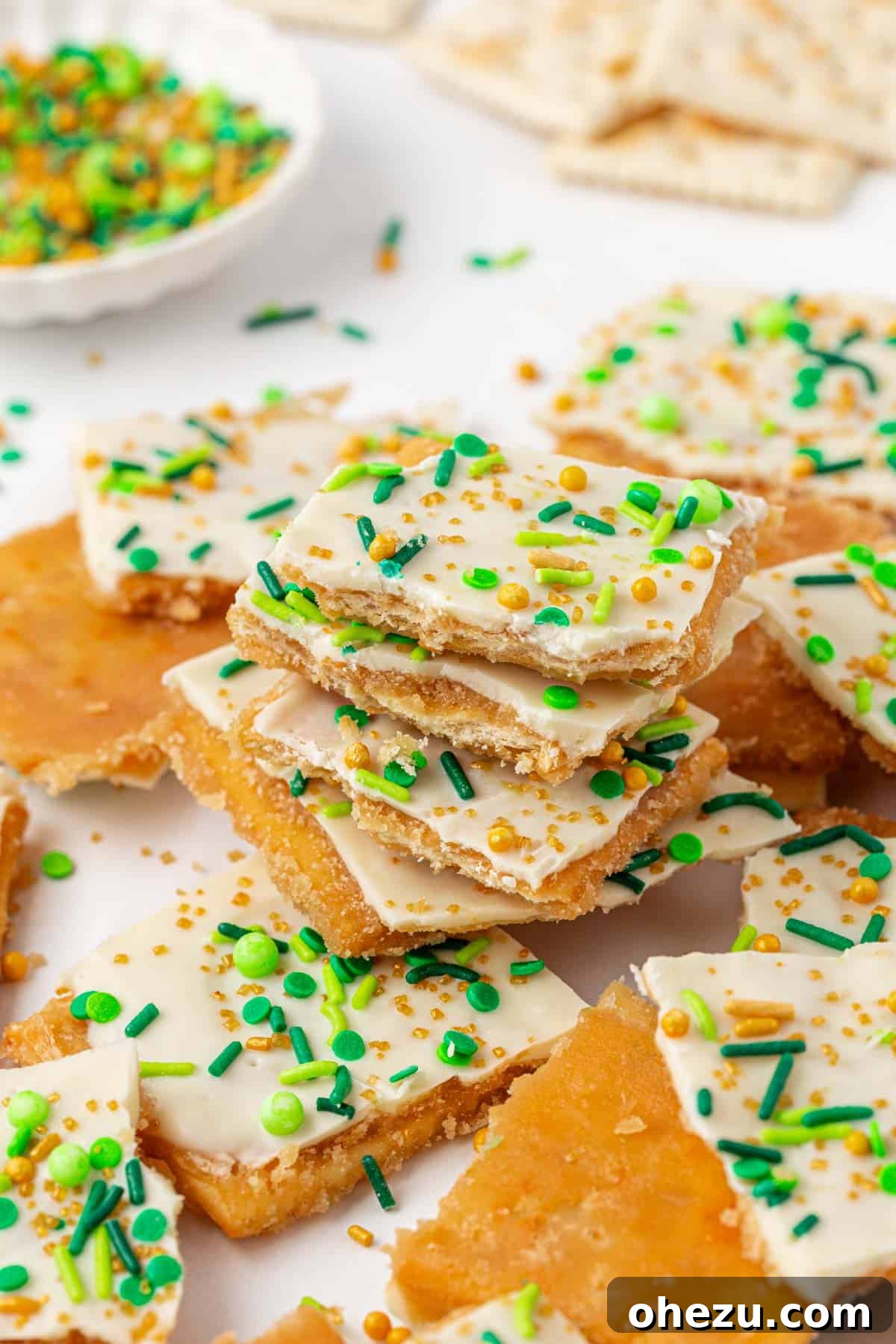 Close-up of St. Patrick's Day saltine toffee with melted white chocolate and colorful sprinkles.