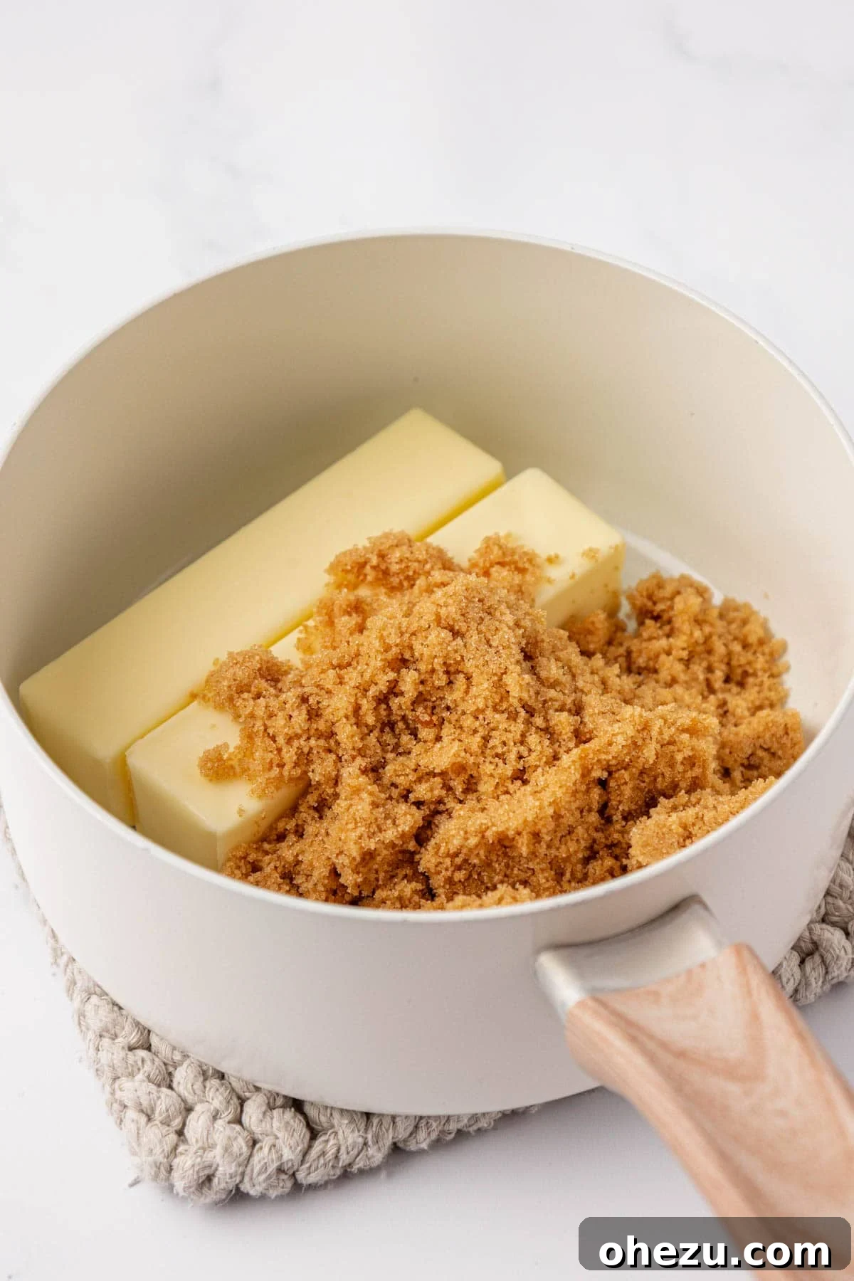 Butter and brown sugar melting together in a saucepan, beginning to form the toffee base.