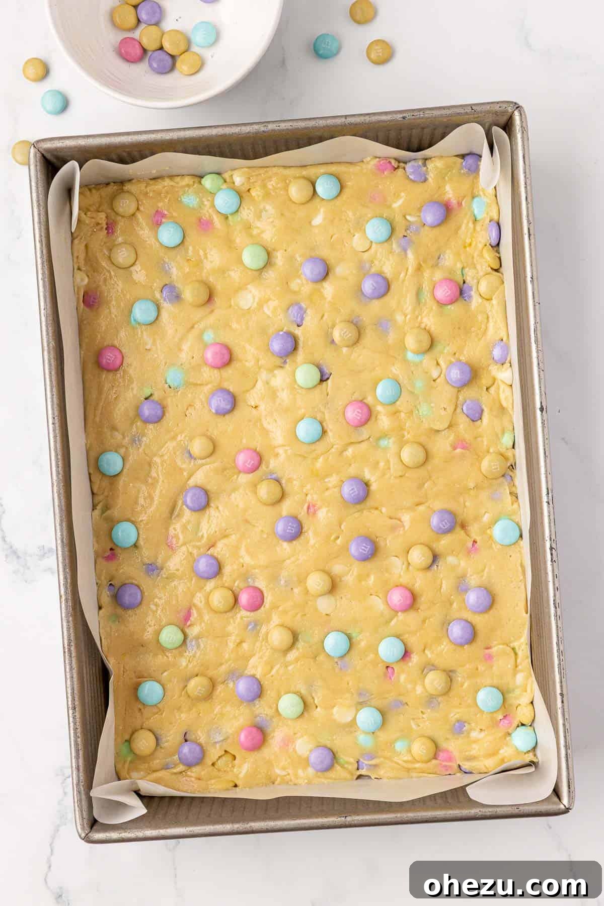 Cookie bar batter topped with additional Easter M&M's before baking.