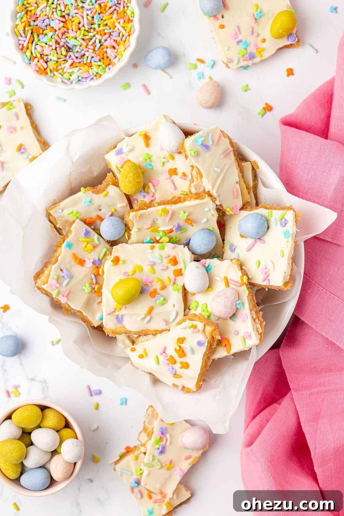 A hand breaking a large slab of frozen Easter crack saltine toffee into smaller, delicious pieces