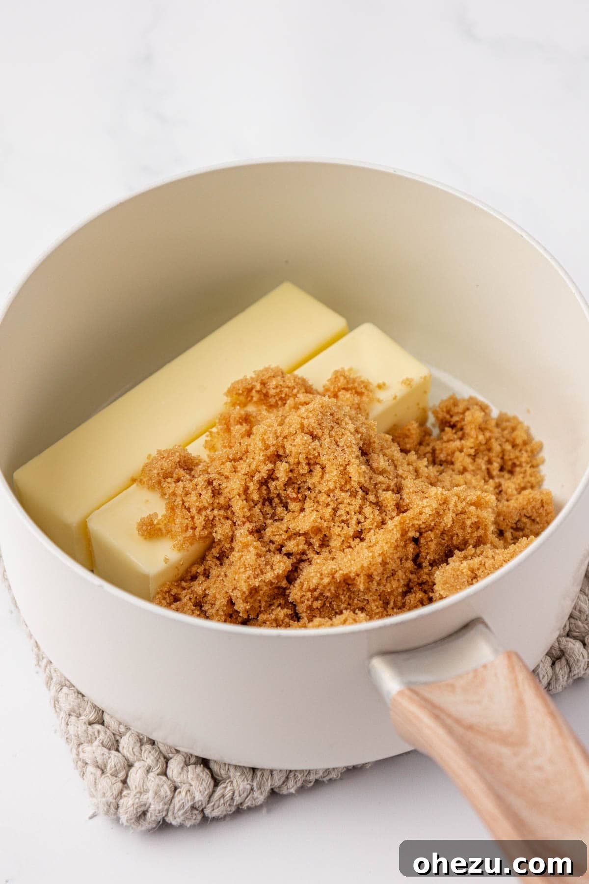 Butter and brown sugar melting together in a saucepan, beginning to form toffee