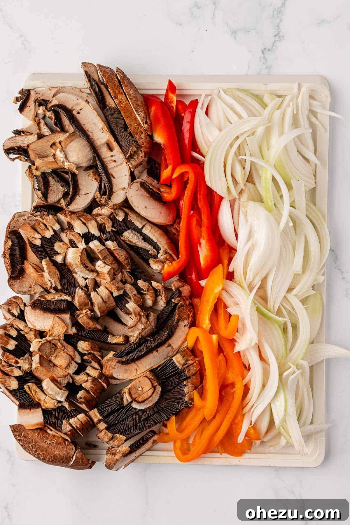 Smoky Portobello Fajita Sizzle 5 Sliced portobello mushrooms, bell peppers, and onions arranged on a sheet pan
