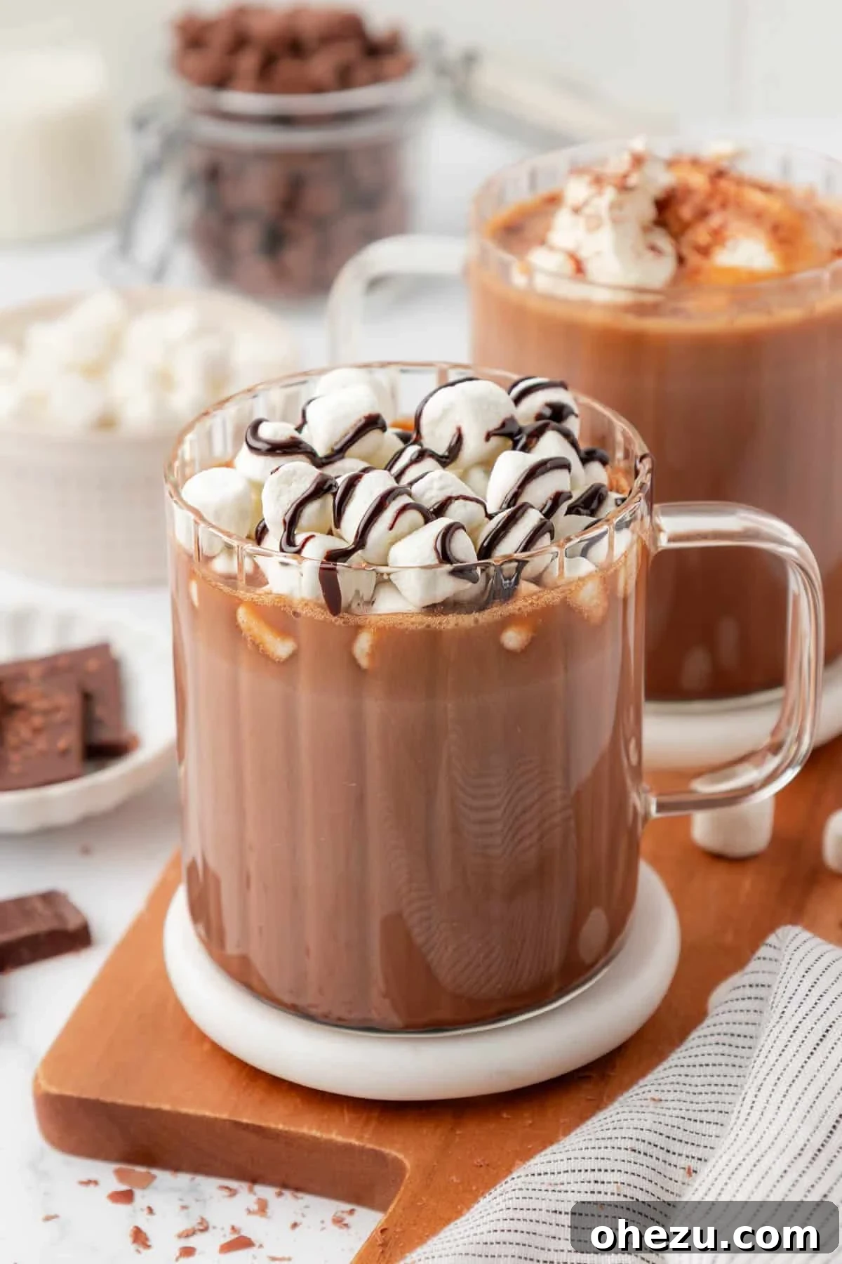 How to Make Rich Homemade Hot Chocolate 2 hot chocolate topped with marshmallows and chocolate syrup