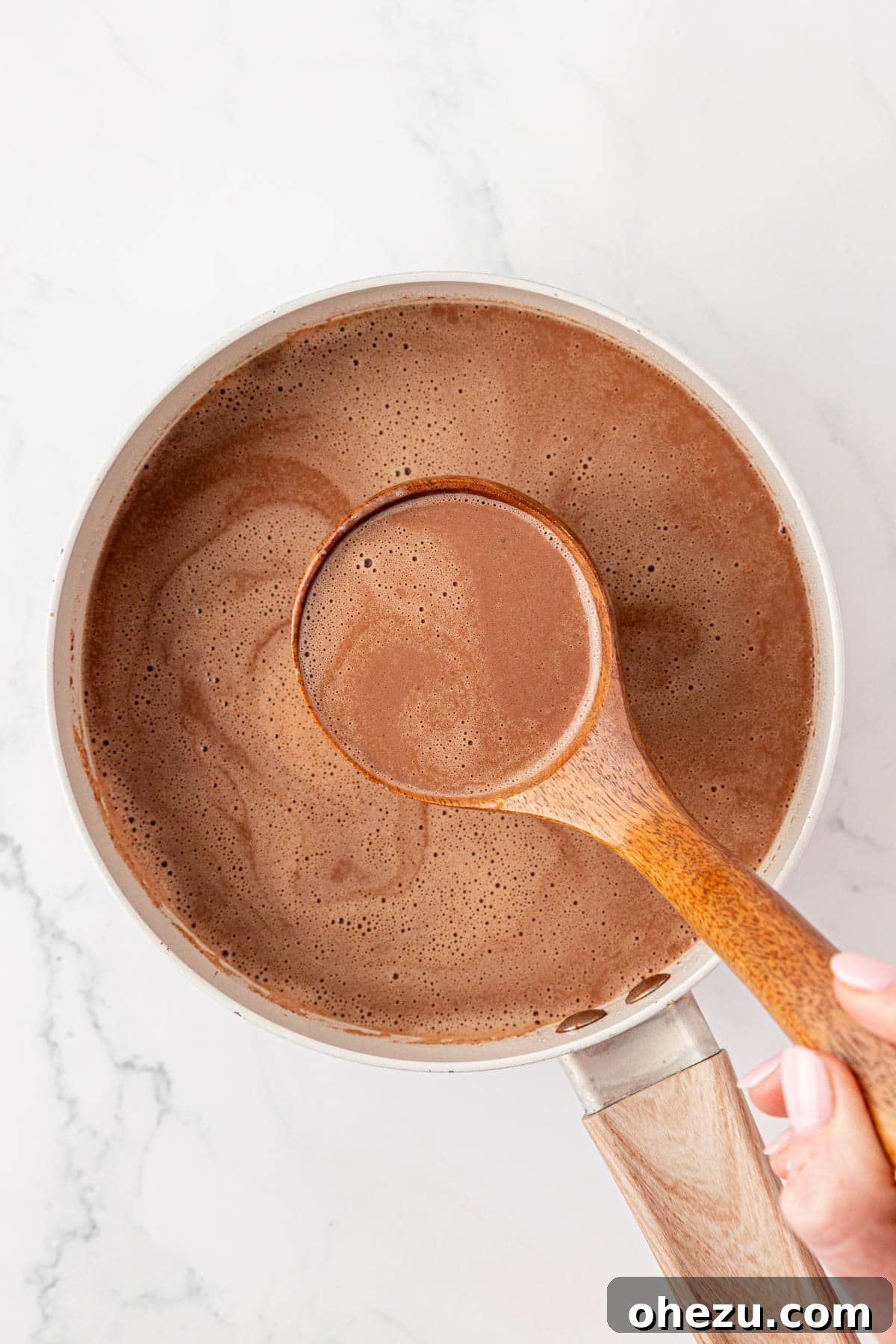 How to Make Rich Homemade Hot Chocolate 9 a ladle with hot chocolate over a pot