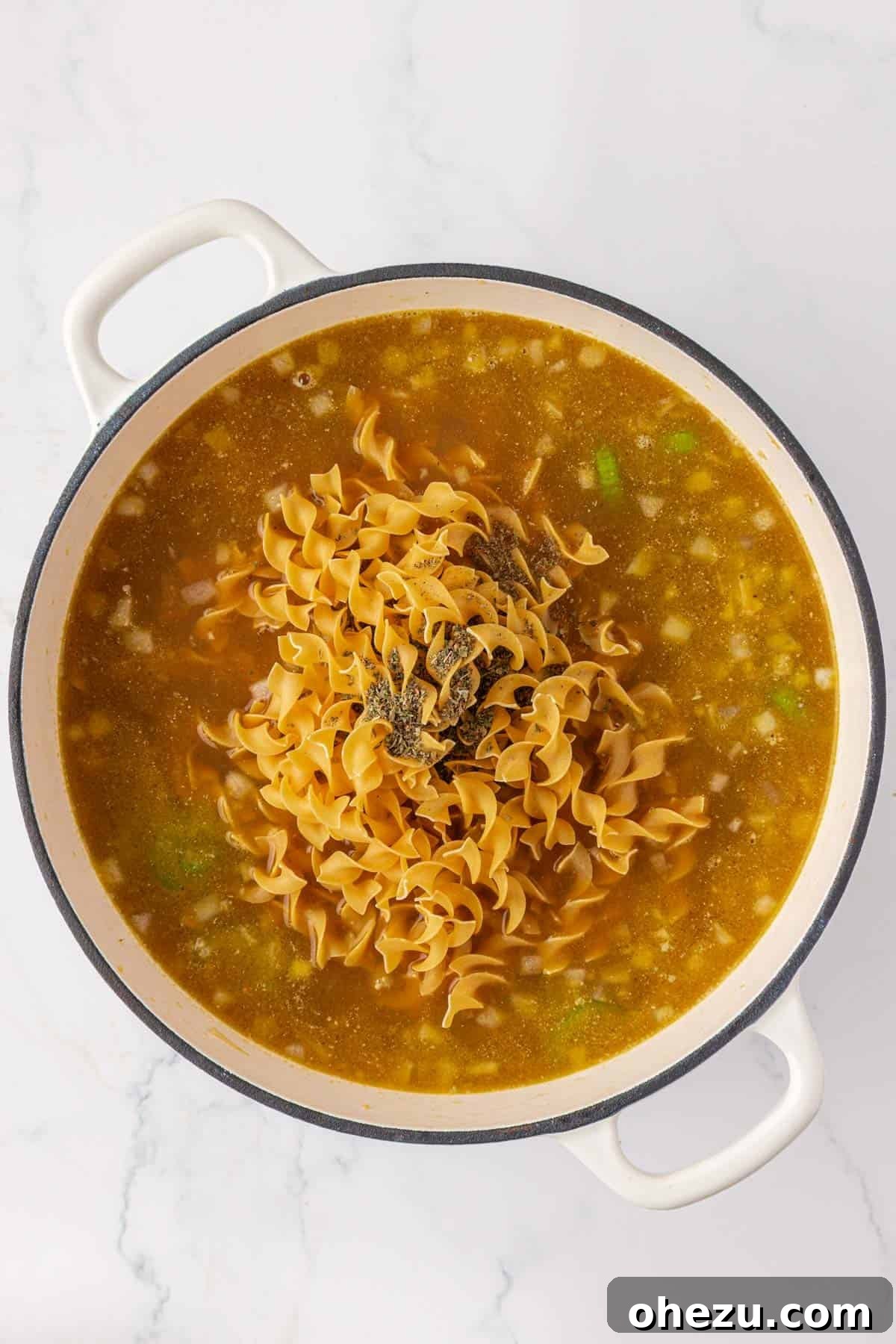 adding the egg noodles and more spices to the pot